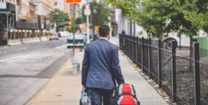 Homme marchant de dos avec une valise